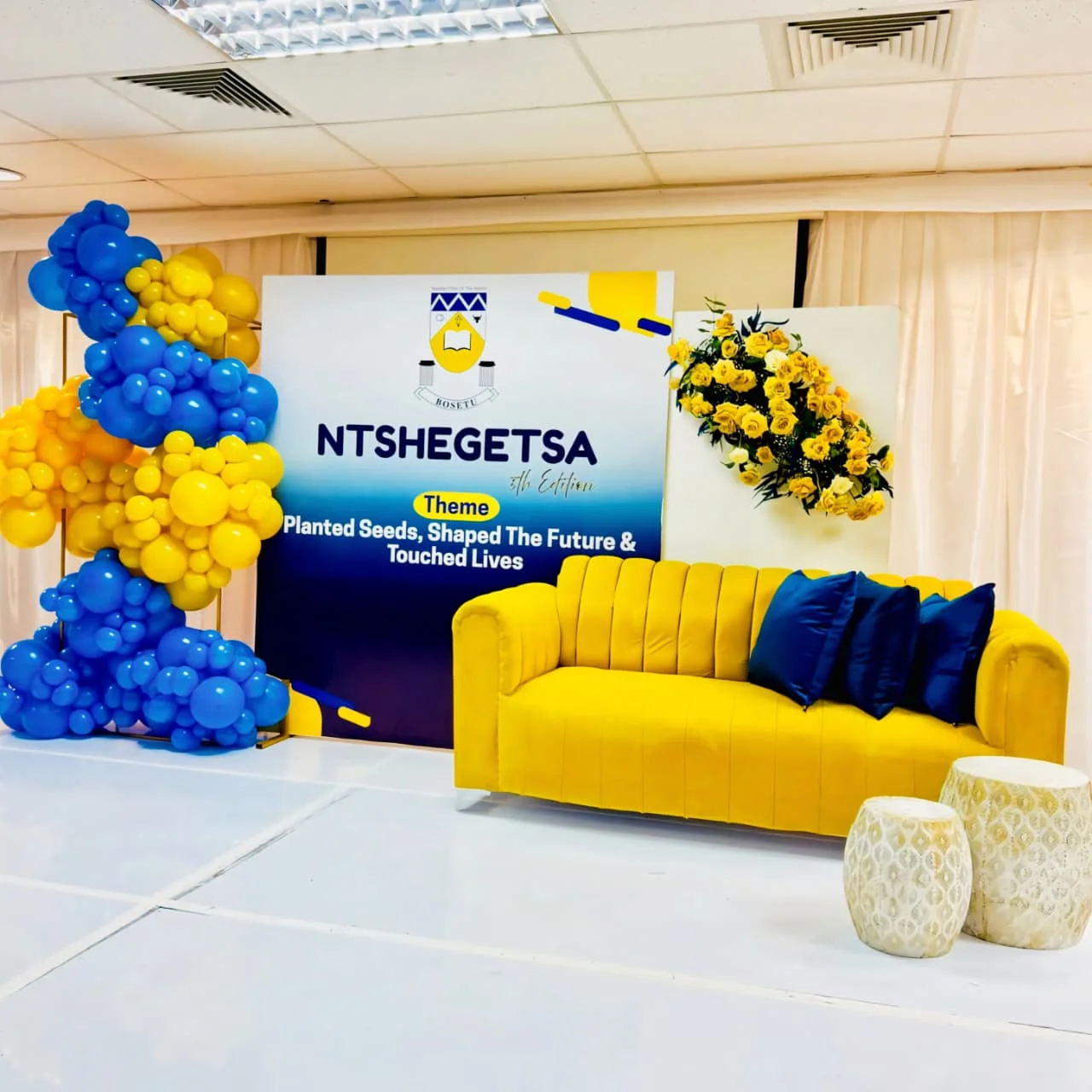 A multi-layered themed decoration backdrop featuring organic balloon clusters and coordinated custom prop cutouts by Sherehe Events.