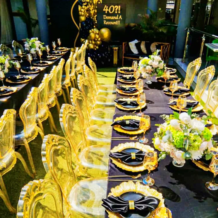 Transparent crystal ghost chair with a subtle amber-gold tint, engineered from durable molded resin for luxury banquet seating setups.