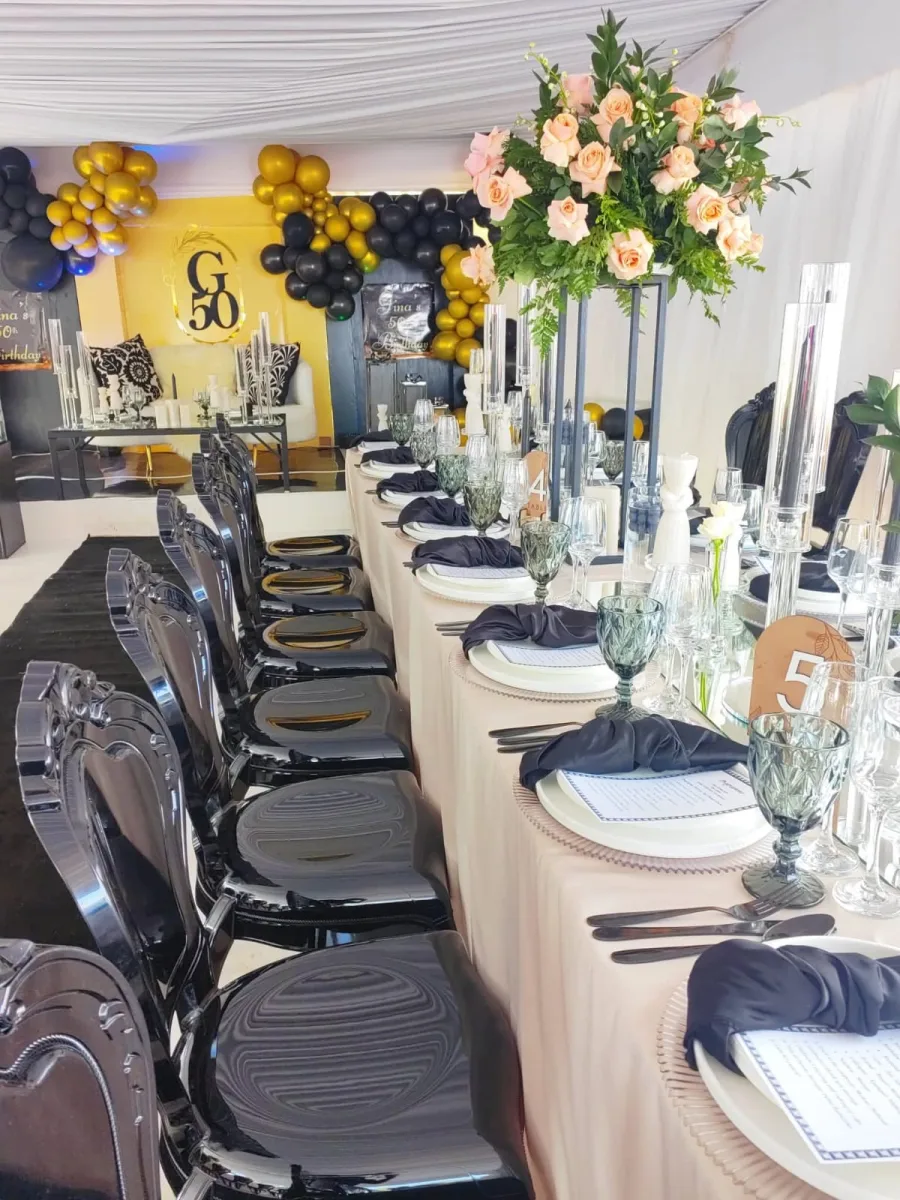 Modern minimalist ghost chairs in alternating solid black and crisp white variants arranged around a formal event reception table.